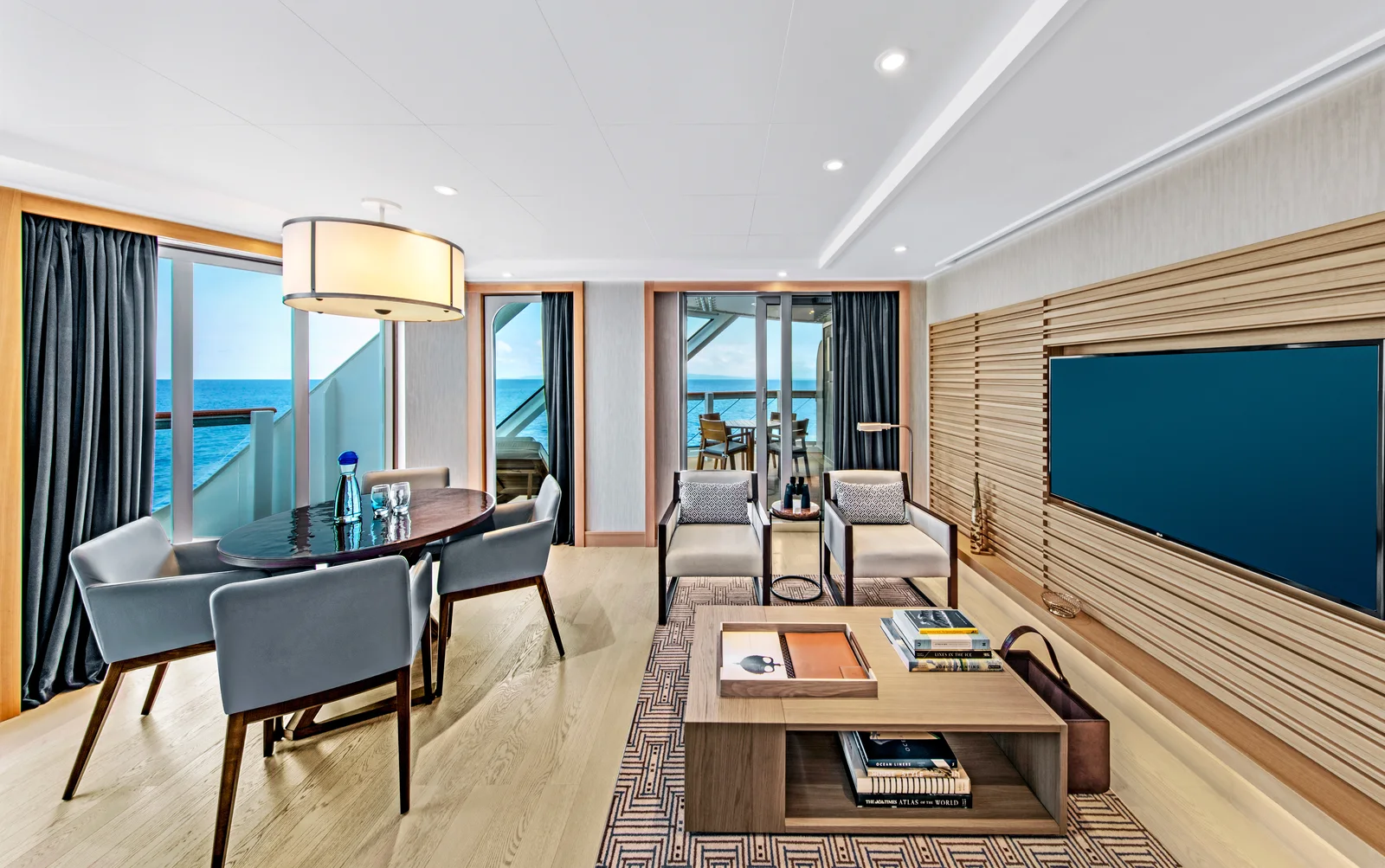 Explorer Suite living room on a Viking ocean ship with large windows, dining table, and veranda access